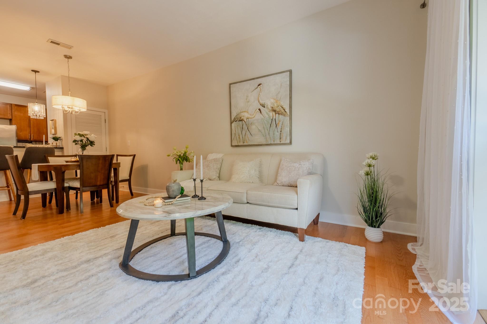 630 Calvert Street, Unit 1110 Charlotte, NC 28208 - Photo 17 of 28 a living room with furniture a dining table and a potted plant
