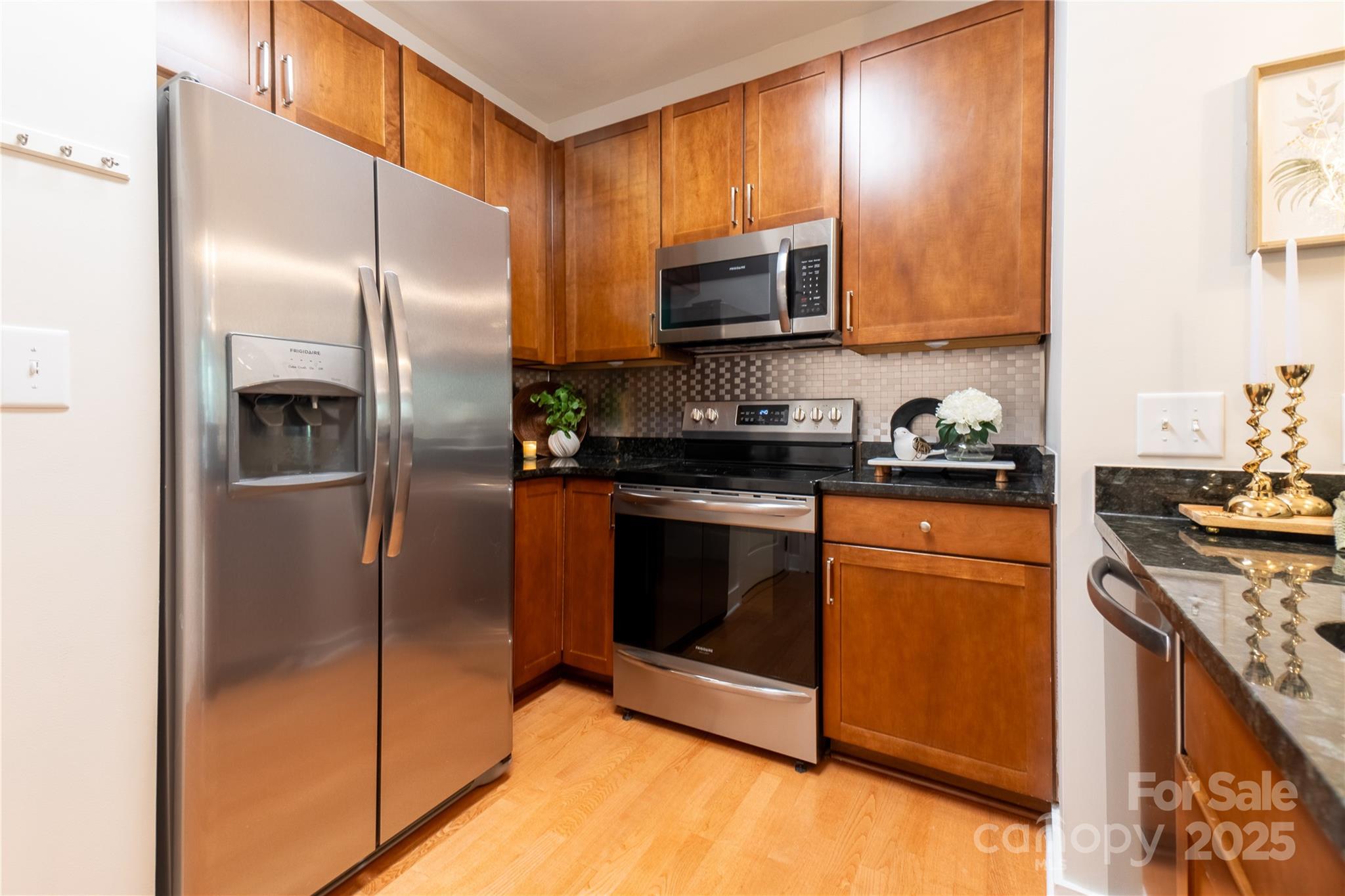 630 Calvert Street, Unit 1110 Charlotte, NC 28208 - Photo 8 of 28 a kitchen with stainless steel appliances granite countertop a refrigerator a stove a sink and a microwave