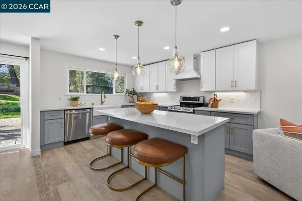 a kitchen with a sink a counter top space a large window and stainless steel appliances