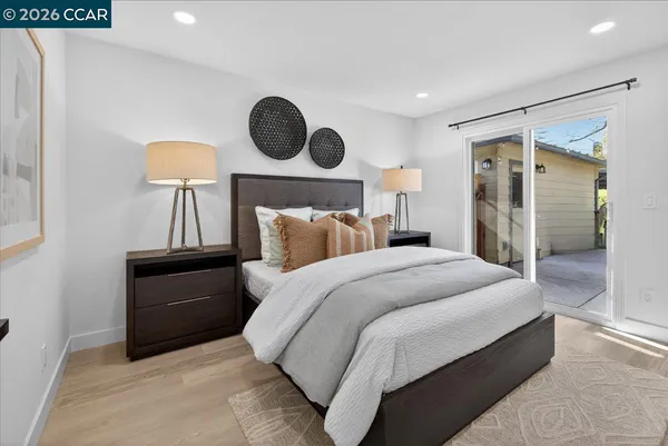 a bedroom with a bed and a lamp on dresser