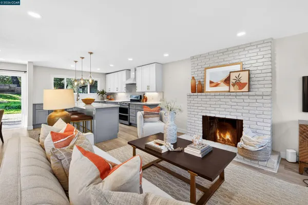 a living room with furniture fireplace and kitchen view
