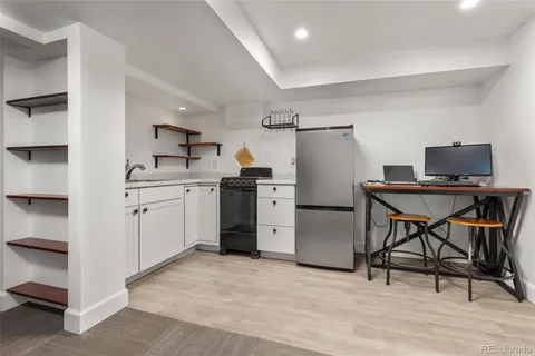 a kitchen with a stove a refrigerator and a table chair