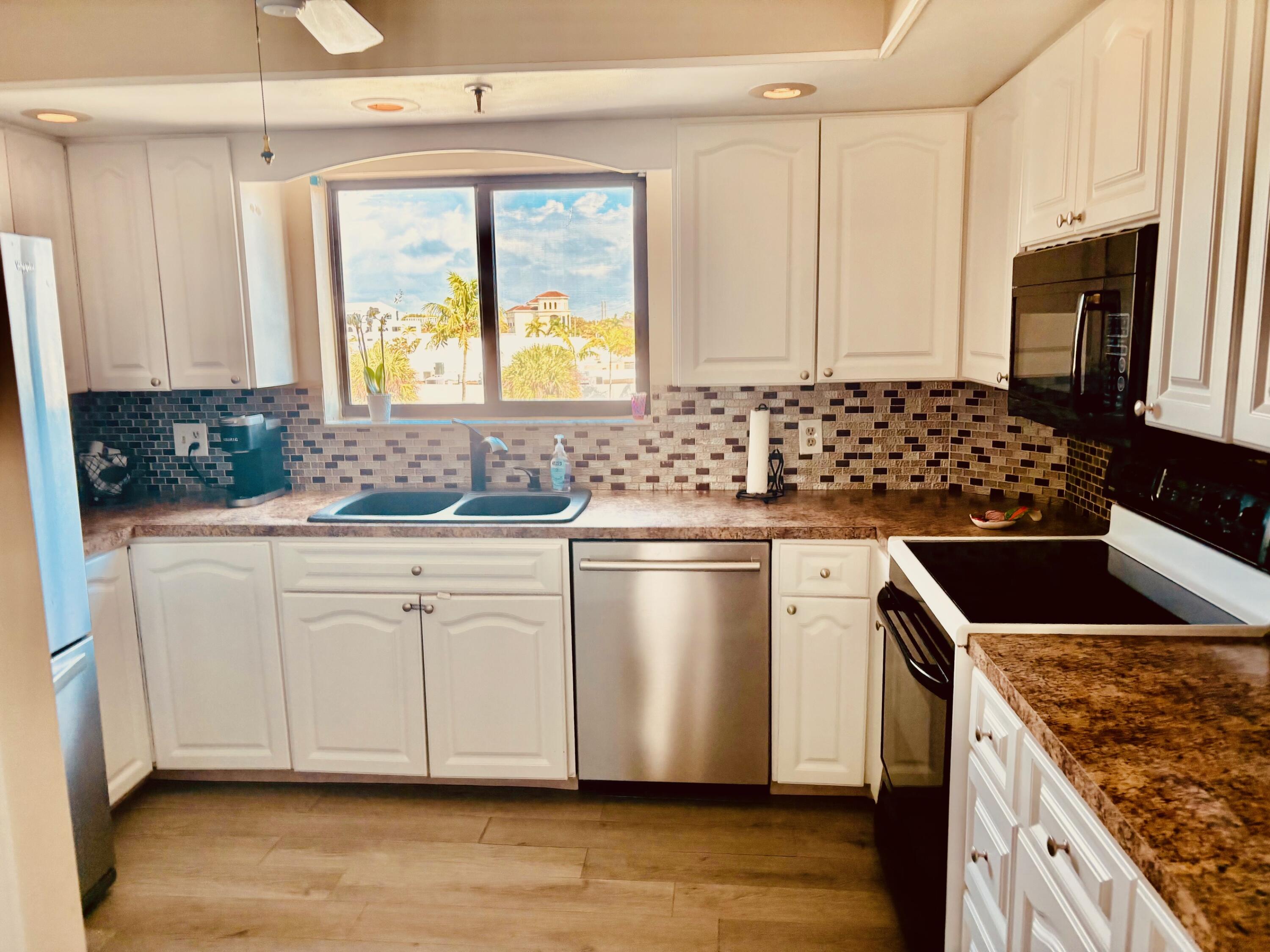300 Golfview Road, Unit 407 North Palm Beach, FL 33408 - Photo 17 of 56 a kitchen with stainless steel appliances granite countertop a sink stove and refrigerator