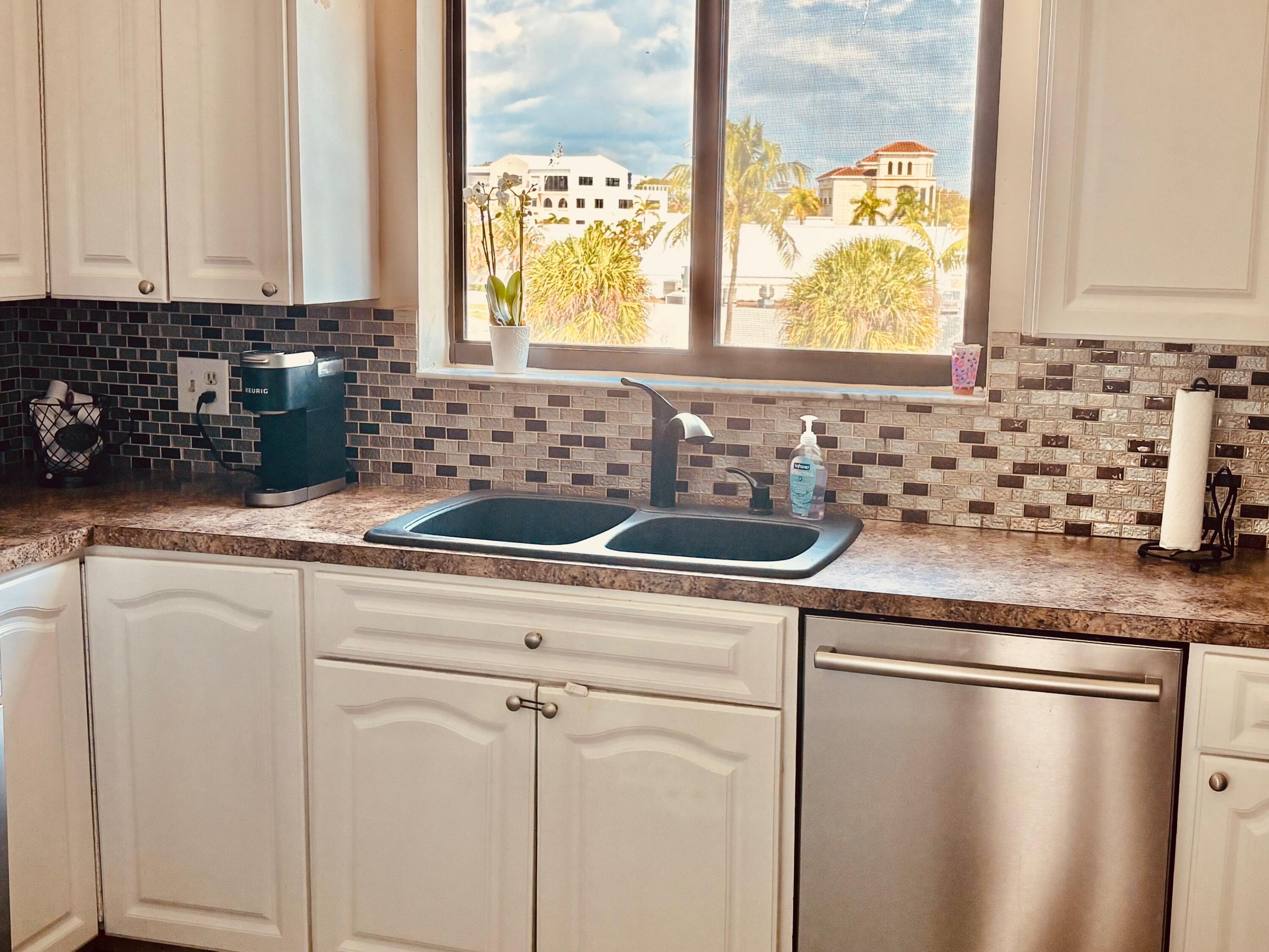 300 Golfview Road, Unit 407 North Palm Beach, FL 33408 - Photo 18 of 56 a kitchen with stainless steel appliances granite countertop a sink a window and a counter space