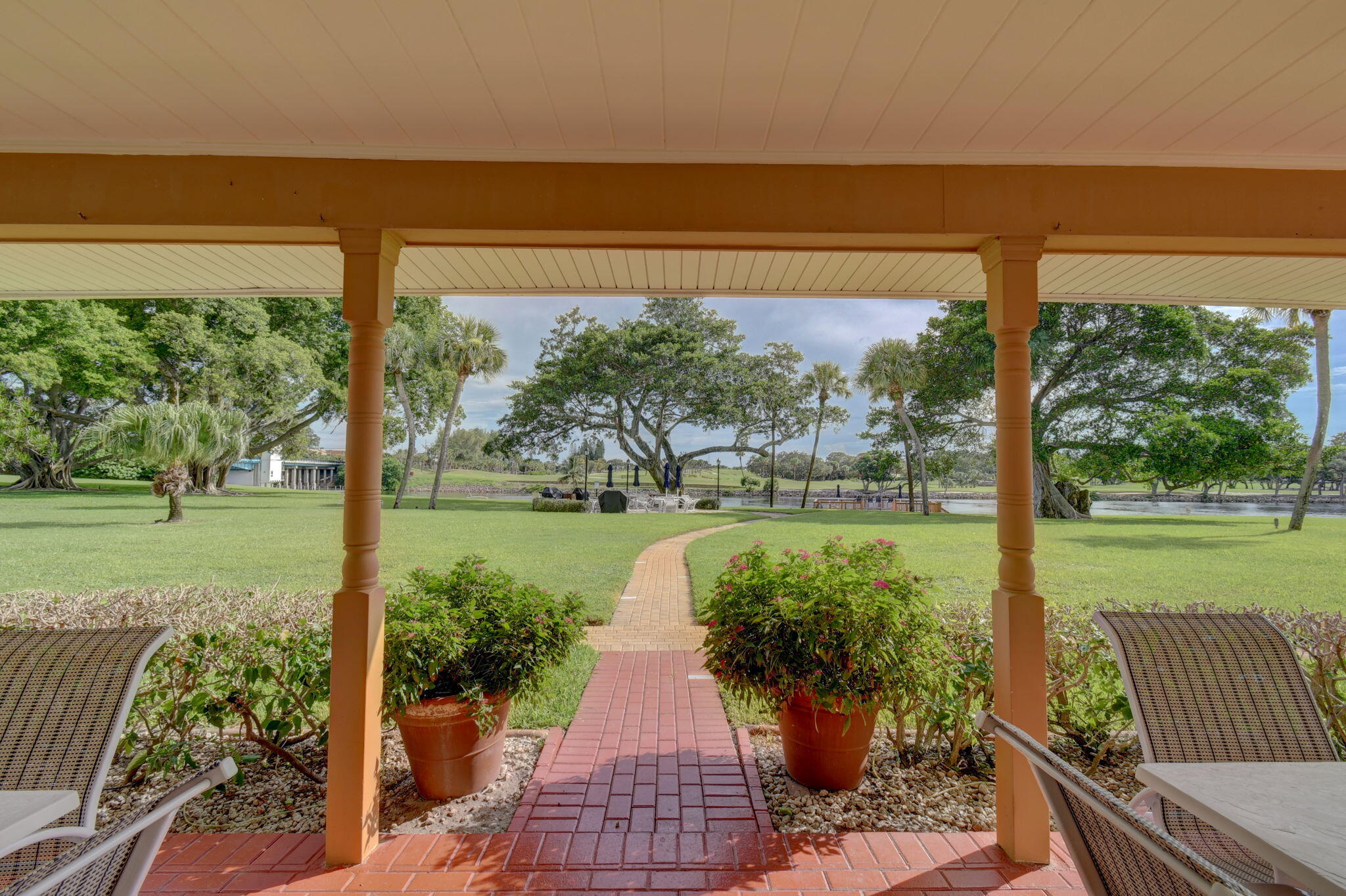 300 Golfview Road, Unit 407 North Palm Beach, FL 33408 - Photo 29 of 56 a view of a patio with lawn chairs floor to ceiling window and an outdoor kitchen