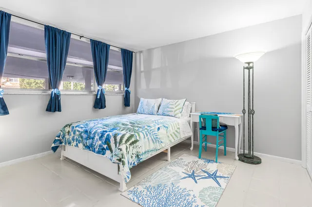 a bedroom with a bed table and window