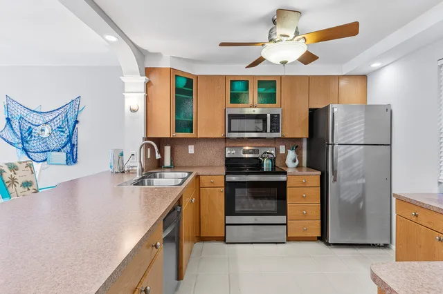 a kitchen with stainless steel appliances granite countertop a refrigerator and a sink