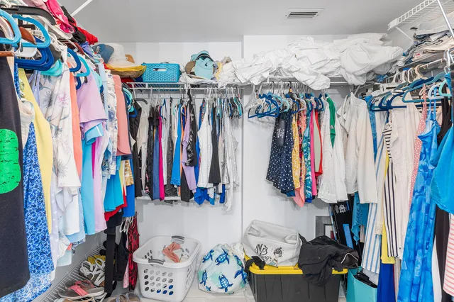a view of walk in closet with clothes