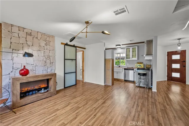 a view of a room with wooden floor and a kitchen