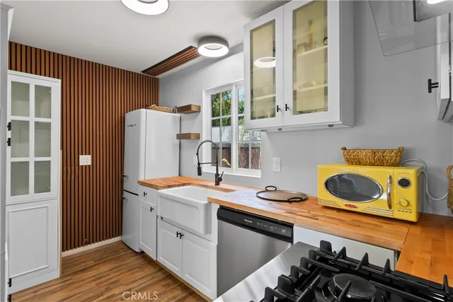 a kitchen that has a stove and a wooden floor