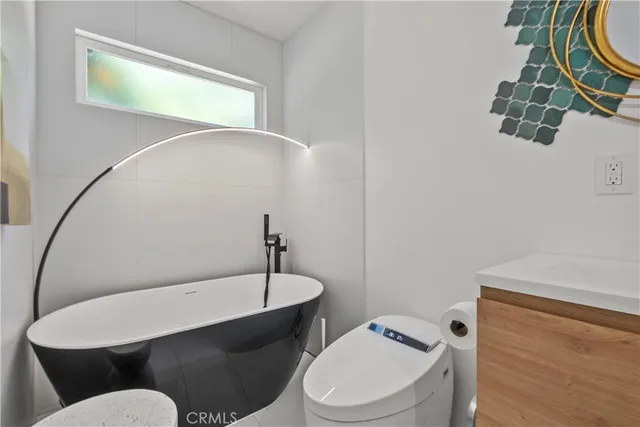 a white toilet sitting next to a bathroom sink and tub