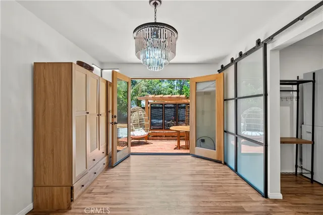 an empty room with wooden floor chandelier fan and windows