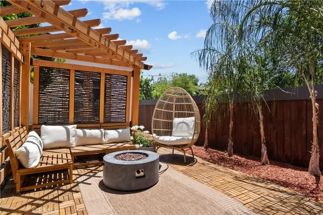 a view of a patio with a dining table and chairs with wooden fence