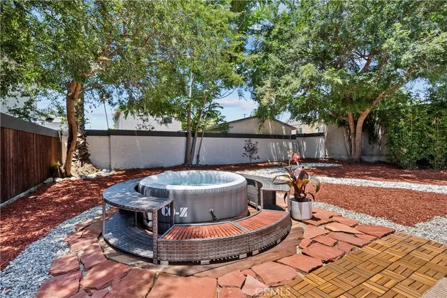a view of a backyard with table and chairs potted plants and tree