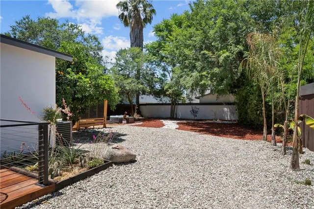 a backyard of a house with barbeque oven and outdoor seating
