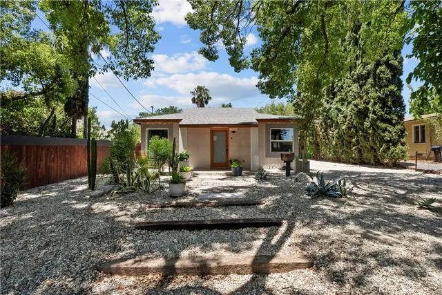 a view of a house with backyard sitting area and garden