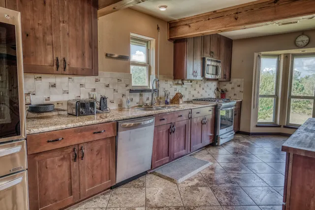 a kitchen with stainless steel appliances granite countertop a sink stove and cabinets