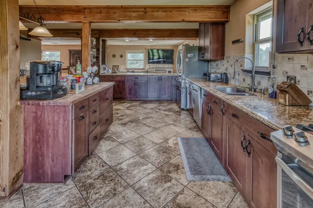 a large kitchen with kitchen island wooden cabinets a sink and a wooden floor