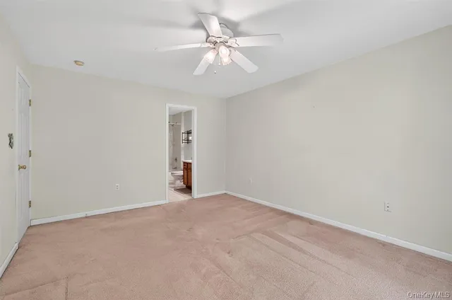 a view of an empty room with a ceiling fan