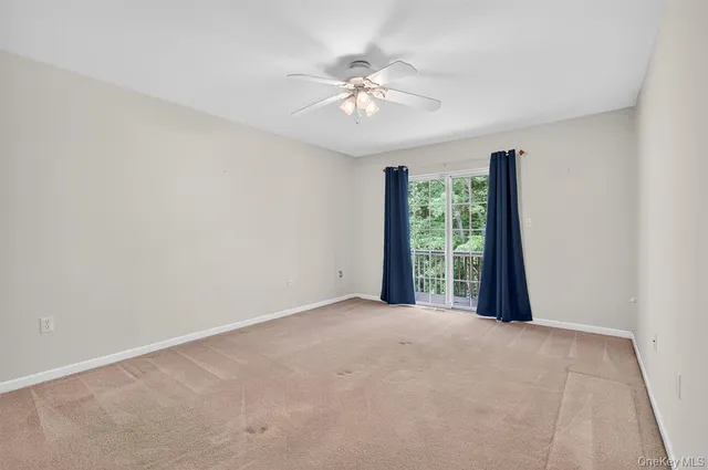 a view of a livingroom with a ceiling fan and window
