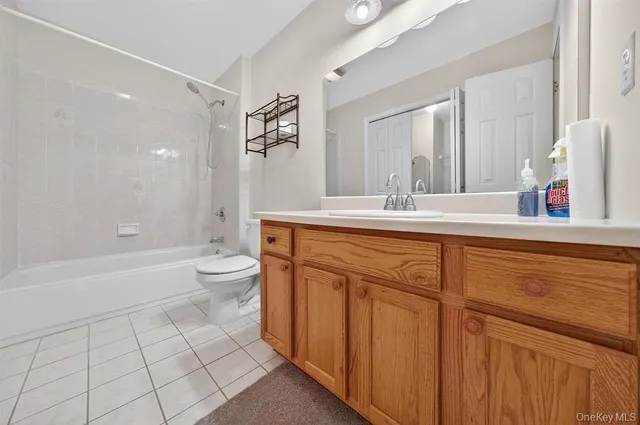 a bathroom with a granite countertop sink a toilet a mirror a vanity a bathtub and shower