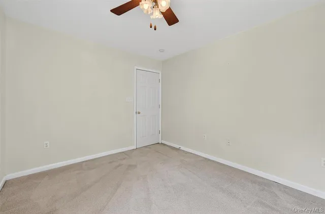 an empty room with a ceiling fan and window