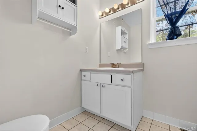 a bathroom with a toilet a sink a mirror and vanity