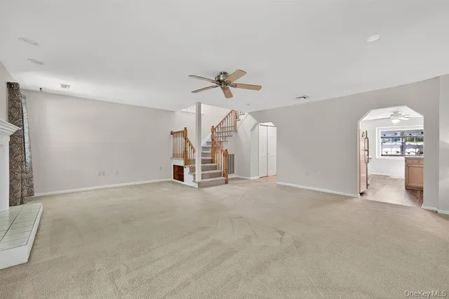 an empty room with a ceiling fan and a window