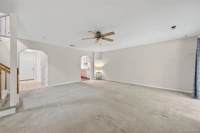 an empty room with ceiling fan and window