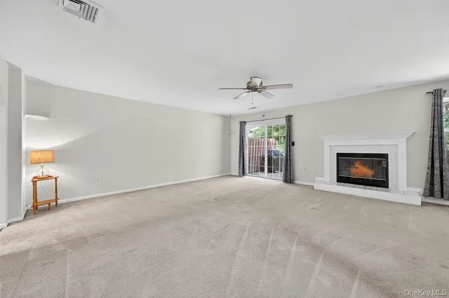 a view of an empty room with a fireplace and a window