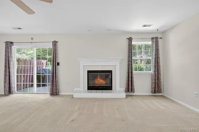 a view of a livingroom with a fireplace and windows