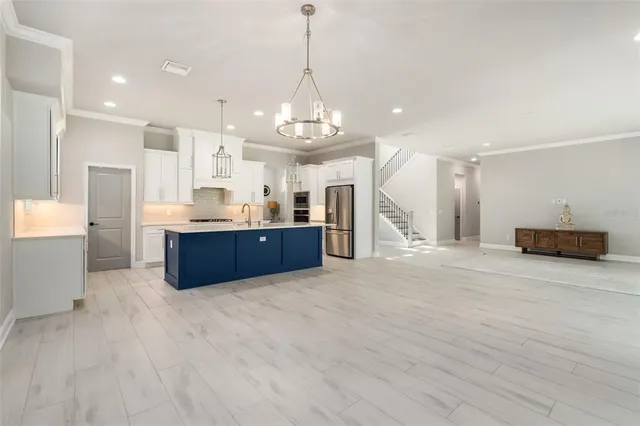 a kitchen with stainless steel appliances kitchen island granite countertop a sink stove and refrigerator