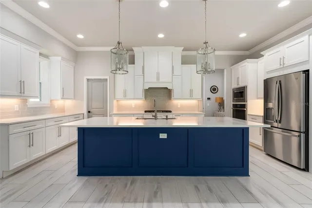 a large kitchen with kitchen island a sink stainless steel appliances and cabinets
