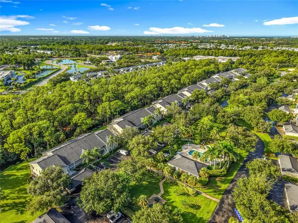 an aerial view of a tennis ground and trees all around