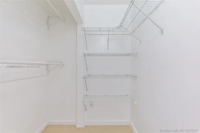 a view of a hallway with wooden floor and a large mirror