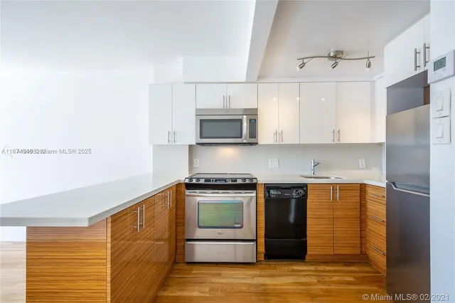 a view of a kitchen with wooden floor and a window