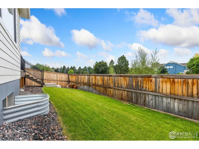 a view of a yard with wooden fence