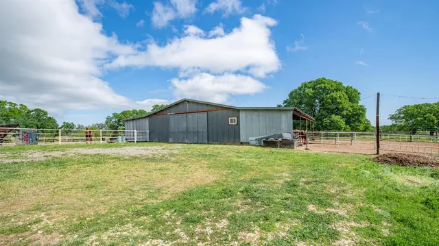 a view of a backyard with table and chairs under an umbrella