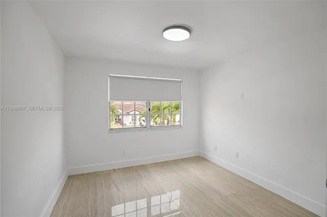 a view of an empty room with wooden floor