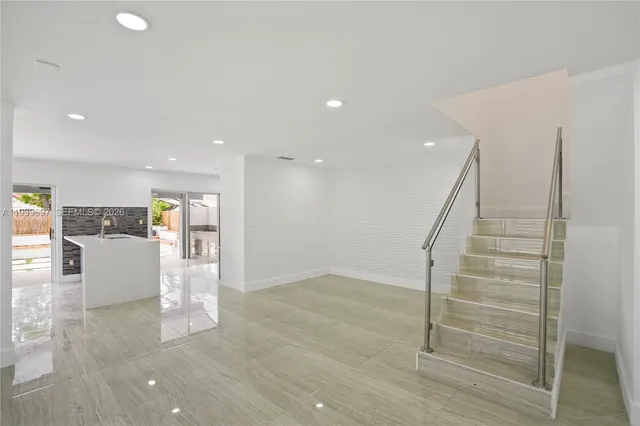 a view of kitchen with kitchen island granite countertop a refrigerator cabinets and a sink