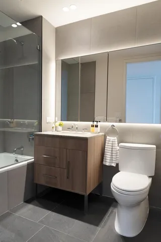 a bathroom with a bathtub sink mirror and toilet