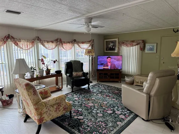 a living room with furniture a flat screen tv and a fireplace