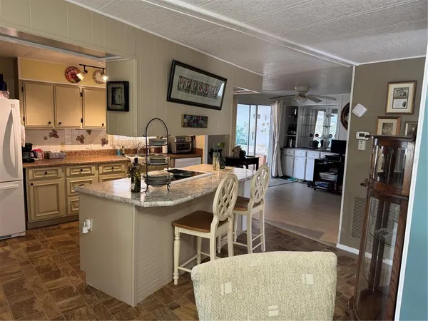a living room with furniture a large window and wooden floor