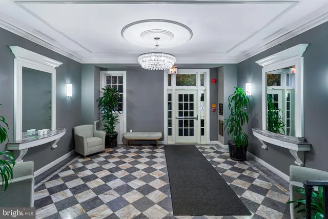a view of a hallway with a chandelier and dining area