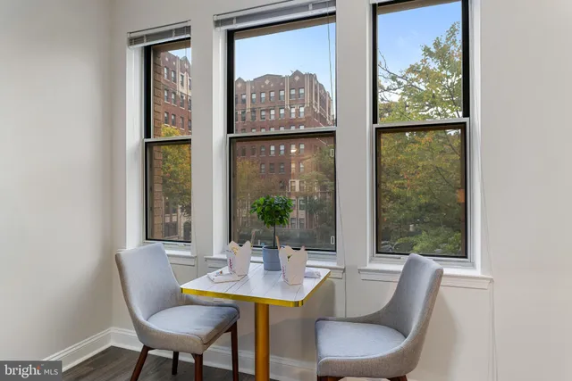 a view of a dining room with furniture a large window and outside view