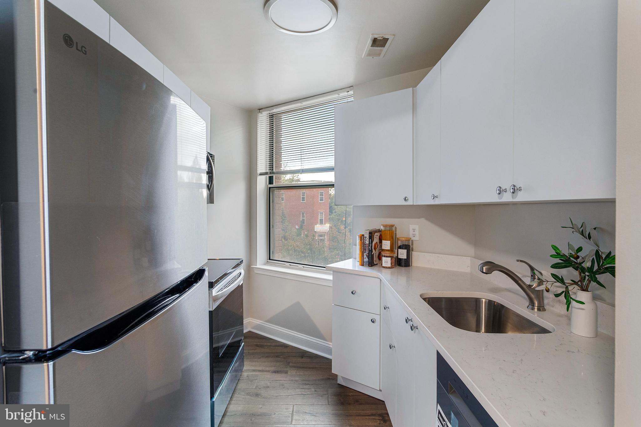 1621 T Street Northwest, Unit 305 Washington, DC 20009 - Photo 10 of 33 a kitchen with a sink and dishwasher a refrigerator with white cabinets