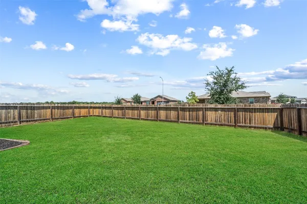 a view of a green yard with a house in the background