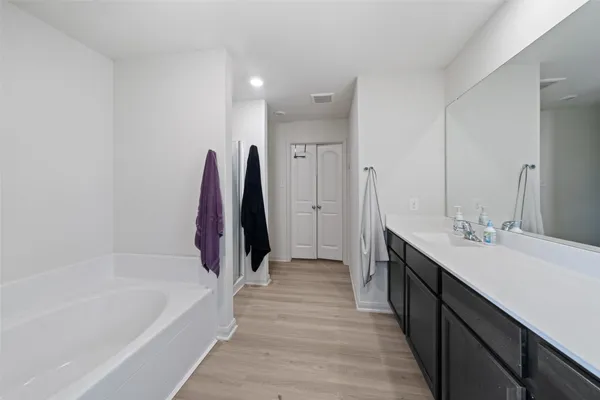 a bathroom with a tub sink and a mirror