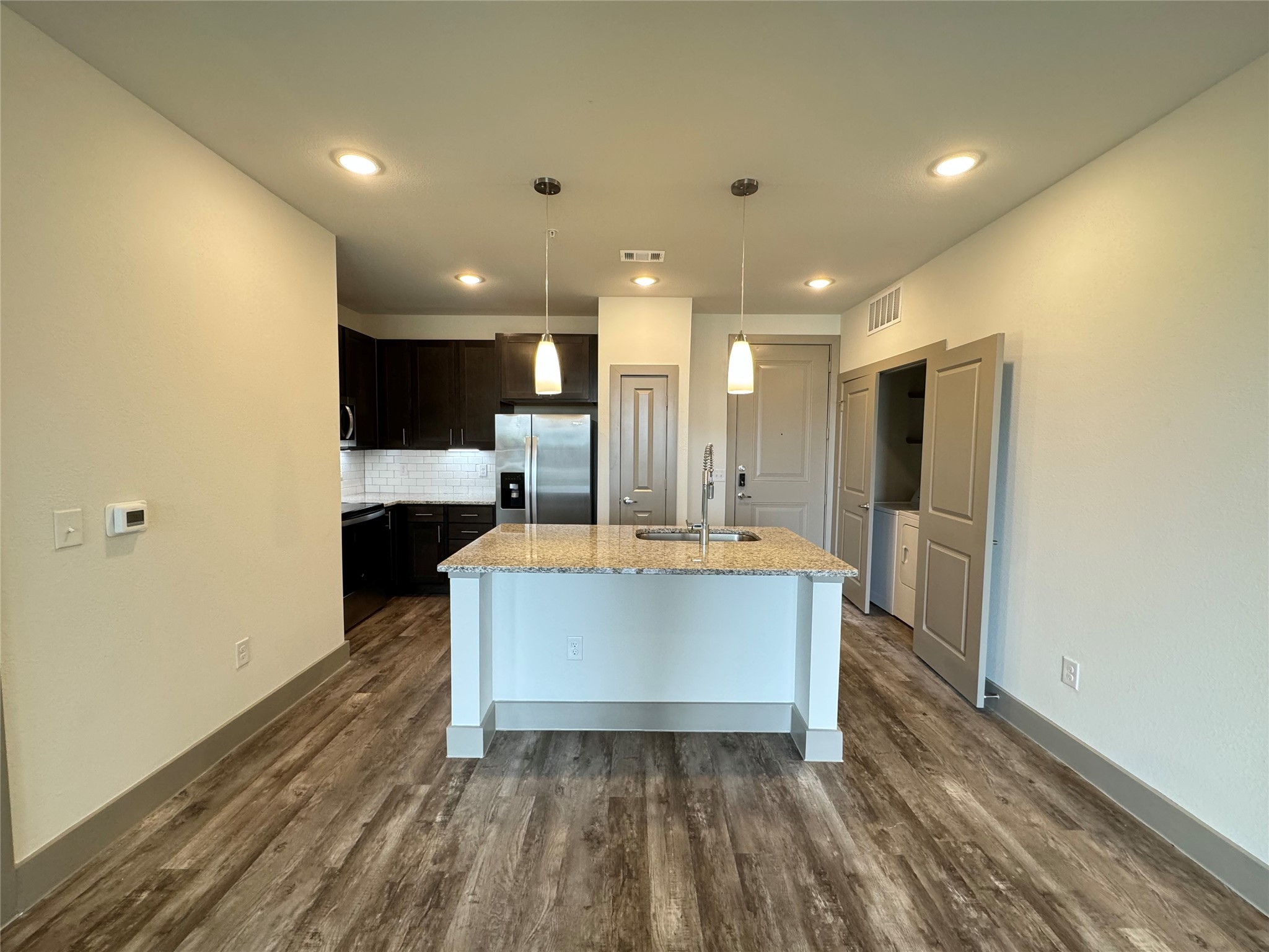20102 Cypress Rosehill Road, Unit A1 1Y Tomball, TX 77377 - Photo 2 of 8 a large kitchen with stainless steel appliances a large counter top a refrigerator and a sink