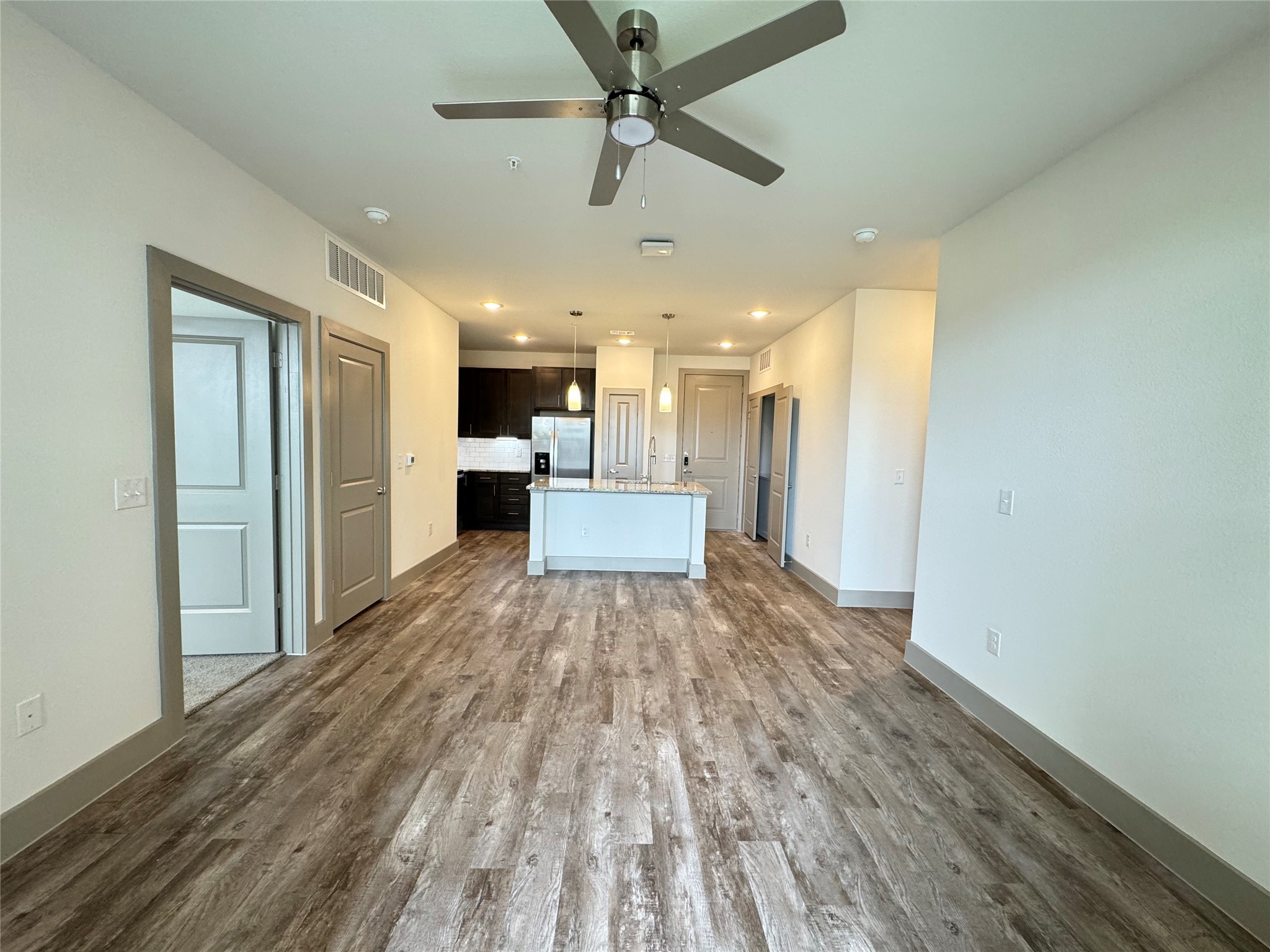 20102 Cypress Rosehill Road, Unit A1 1Y Tomball, TX 77377 - Photo 6 of 8 a view of a big room with wooden floor and a kitchen space